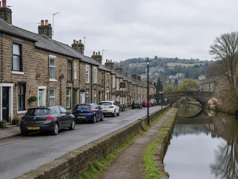 Stone terraced houses beside a canal in a West Yorkshire valley