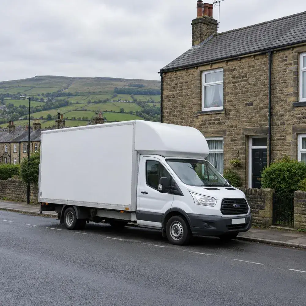 White removal van parked outside a stone terraced house with Pennine hills behind